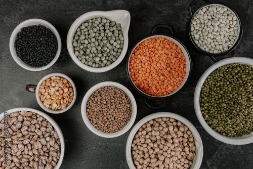 Many bowls of various legumes.Dark background.Top view