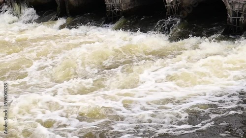 Environmental pollution, environmental disaster. Discharge of polluted sewage into the river from factory concrete pipes. Hazardous waste water. Environmental protection. Water pollution.