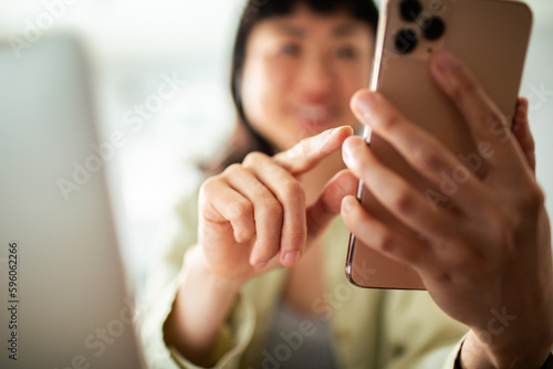 Young Japanese woman using a smart phone in the living room