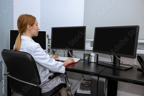Professional scientist woman doctor surrounded by monitors working on personal computers
