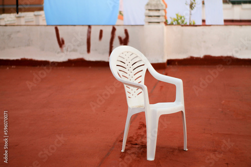 Solitude in the City: Minimalist Chair on Rooftop with Panoramic View of Urban Landscape at Sunset