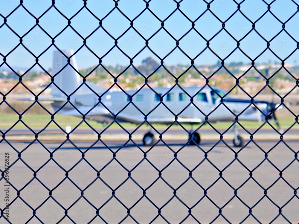 Flugzeug hinter Maschendrahtzaun Flugzeug hinter Maschendrahtzaun