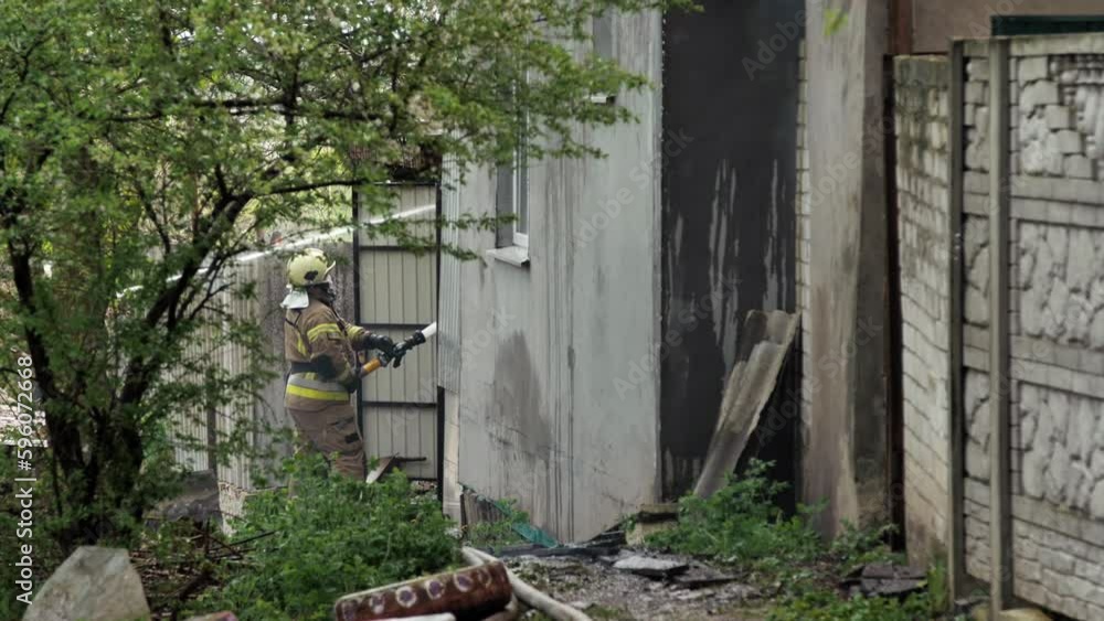 Firefighters extinguish a private house from fire hoses with water during a fire. Firefighters extinguish a private house from fire hoses with water during a fire.