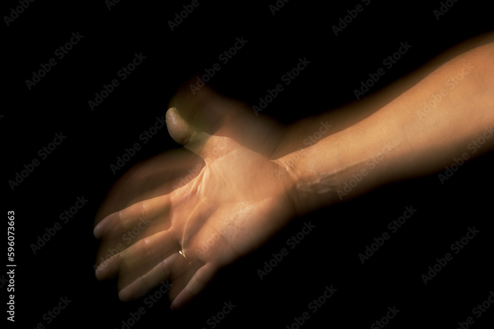 Offering the palm of the hand. Low key with motion trail Offering the palm of the hand. Low key with motion trail