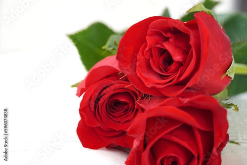 Bouquet of red roses with herringbone. White wall and space for text. Sant Jordi s Day  a popular festival in Catalonia.