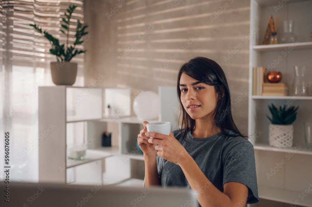 Portrait of a young businesswoman enjoying her coffee and looking at the camera. Portrait of a young businesswoman enjoying her coffee and looking at the camera.