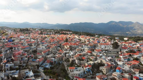 Aerial pan view popular tourist attraction Pano Lefkara village on Cyprus, Europe. Flying over majestic cityscape with greek orthodox church on the beautiful green hills in summer photo