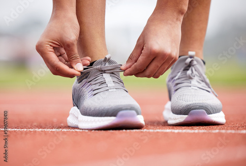 Shes knot in the mood to stumble. an unrecognizable female athlete tying her laces out on the track.