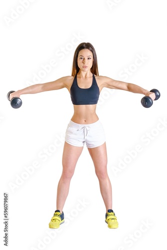 Athletic young girl with two dumbbells in hand doing stretching exercise sporty woman in white shorts black top yellow sneakers lifting dumbbels fitness model exercising with dumbbells in white room