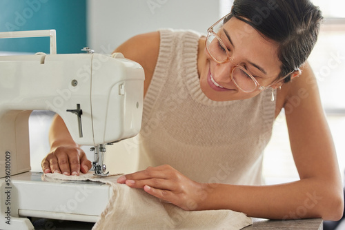 Just a woman who loves sewing. a young woman using a sewing machine in her workshop.