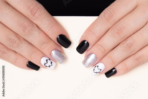  Beautiful female hands with black manicure nails  hearts design  on white background