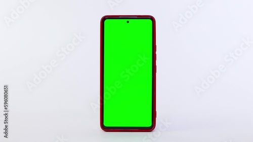 Celular con pantalla verde, funda roja y fondo blanco photo