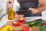 cropped view of man preparing food and looking at tablet