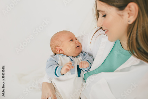 Happy mother and baby boy, wearing casual clothes on white background.