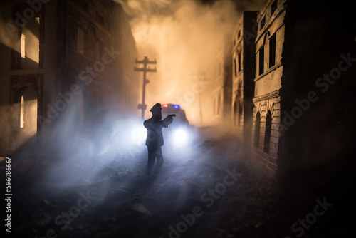 Police raid at night and you are under arrest concept. Silhouette of handcuffs with police car on backside. Image with the flashing red and blue police lights at foggy background. Slider shot