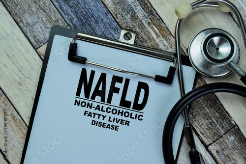 Concept of NAFLD - Non-Alcoholic Fatty Liver Disease write on paperwork with stethoscope isolated on Wooden Table. photo