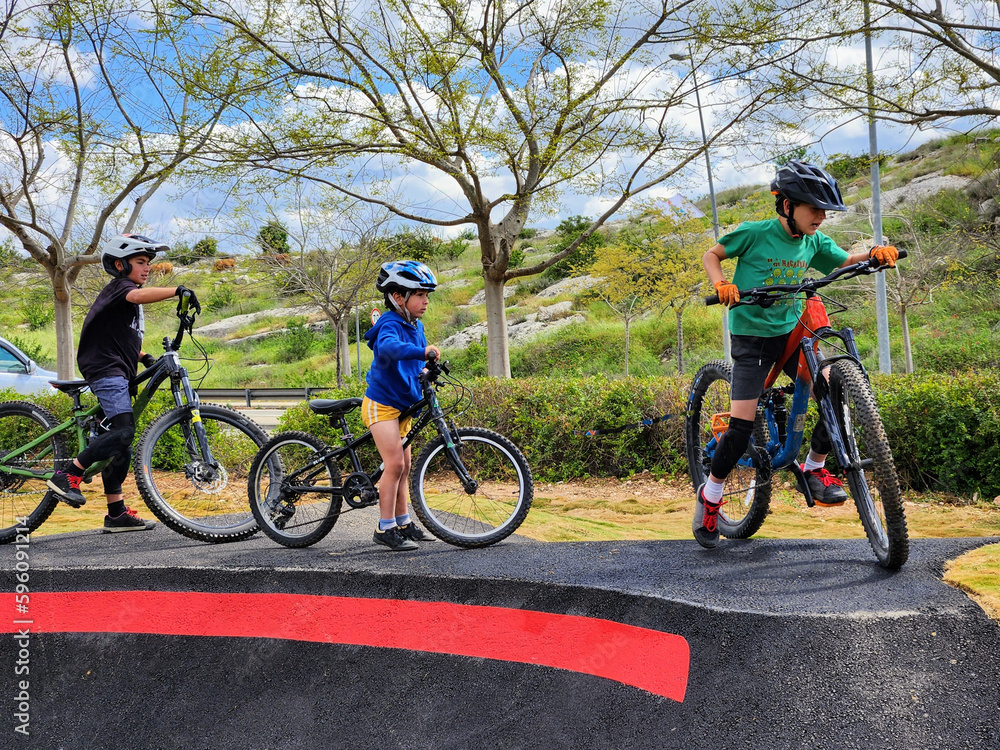 3 brothers bikers with their bikes at a pumptrack 3 brothers bikers with their bikes at a pumptrack