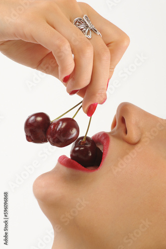 Young woman with cherries on her lips, isolated on white background