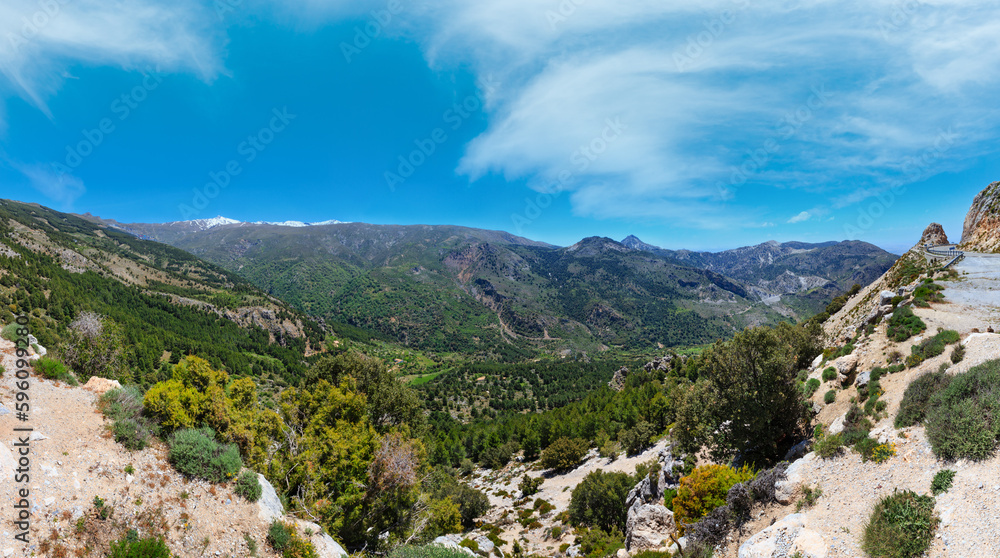 Summer mountain landscape with snow on peak and road (Sierra Nevada National Park, near Granada, Spain).