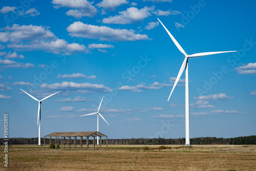 wind turbine in the wind, three windmills in the field