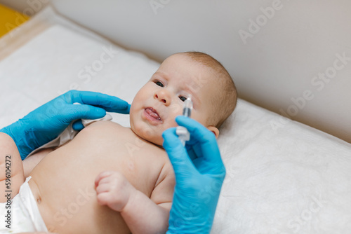 Pediatrician administring oral vaccination against rotavirus infection to little baby. Children health care and disease prevention. 