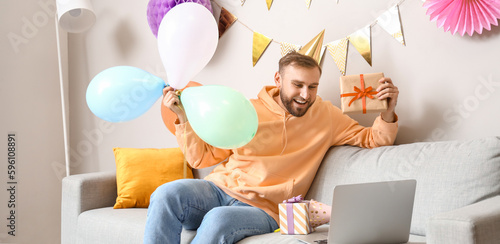 Happy young man with laptop...