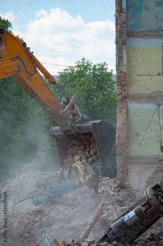 Demolition of building. Excavator breaks old house. Freeing up space for construction of new building