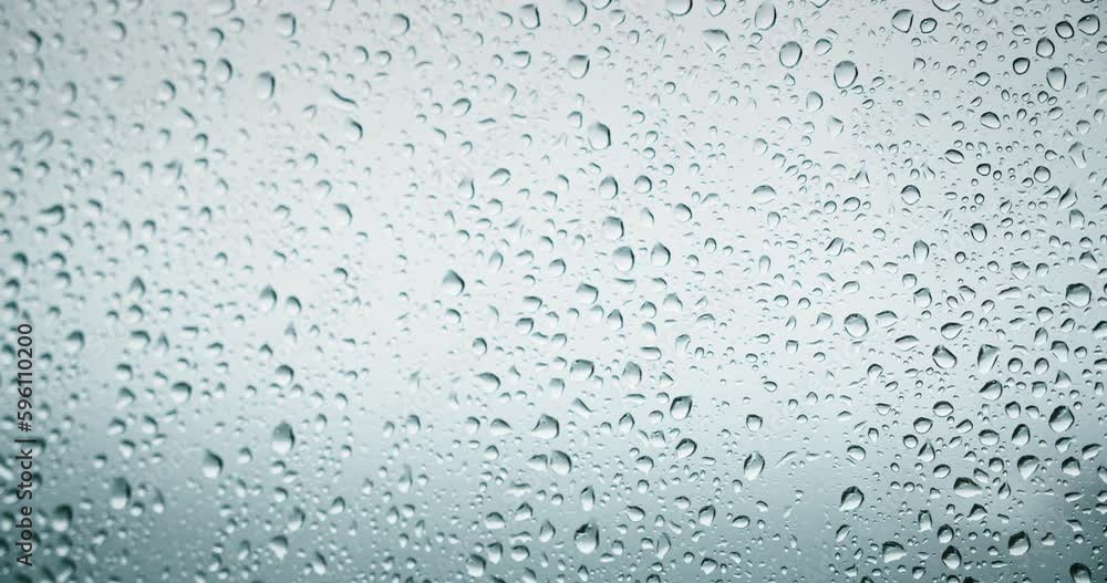 Rain water drops on window transparent glass abstract background. Natural bad weather gray colors. Rain water drops on window transparent glass abstract background. Natural bad weather gray colors.
