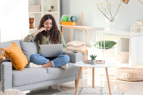 Teenage girl using laptop o...