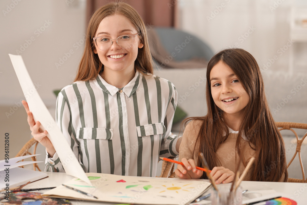 Drawing teacher giving private art lesson to little girl at home Drawing teacher giving private art lesson to little girl at home