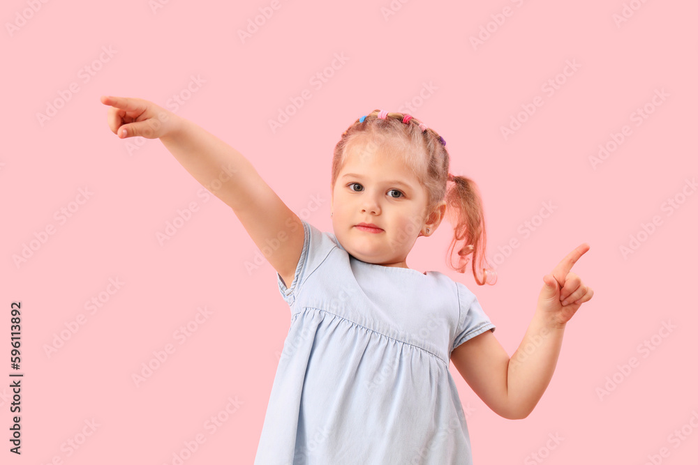 Funny little girl showing loser gesture on pink background Funny little girl showing loser gesture on pink background