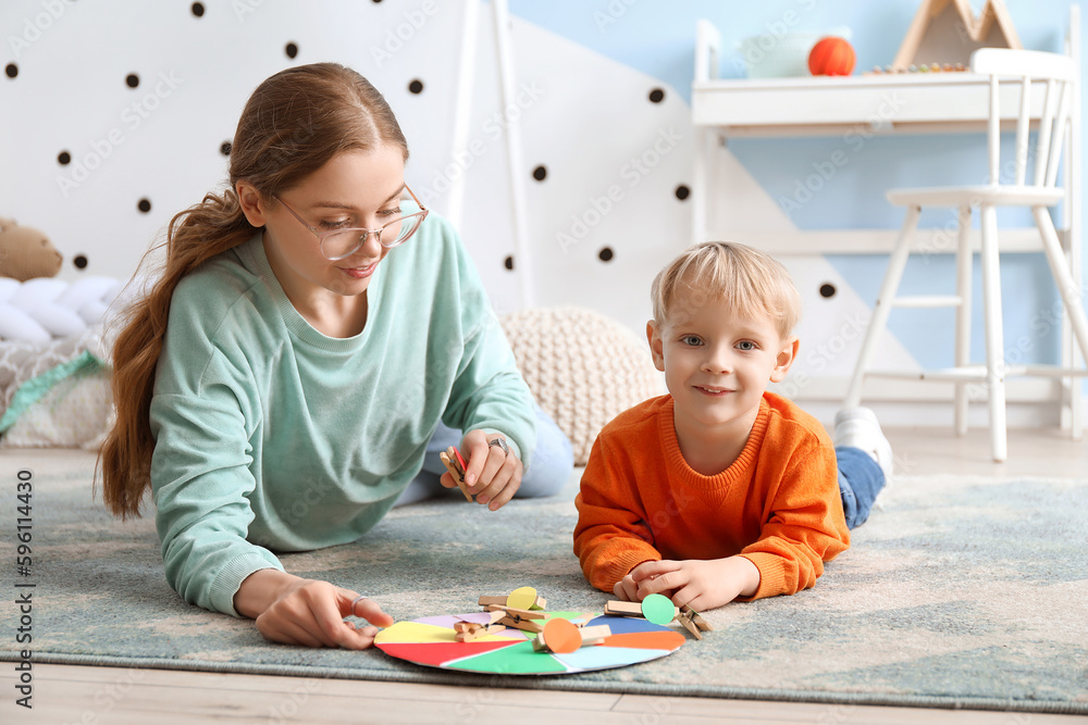 Cute little boy and his mother playing matching game with clothespins at home Cute little boy and his mother playing matching game with clothespins at home