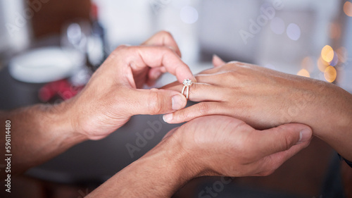 A hand like yours needs a pretty ring. an unrecognizable man putting a ring on his girlfriends finger at home.