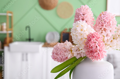 Fotografie Vase with beautiful hyacinth flowers in kitchen, closeup