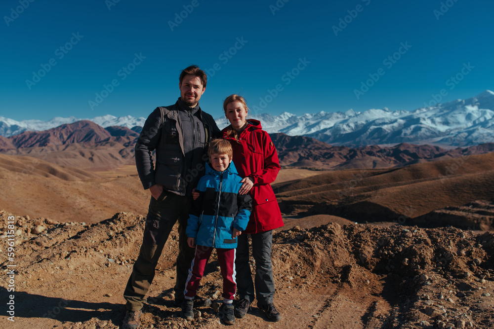 Father, mother and son posing on mountains background at autumn