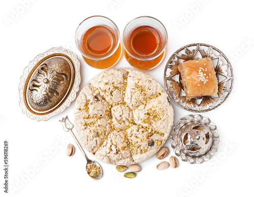 Tasty Tahini halva with pistachios, baklava and glasses of tea on white background photo