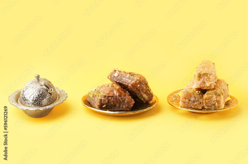 Plates with tasty baklava on yellow background Plates with tasty baklava on yellow background