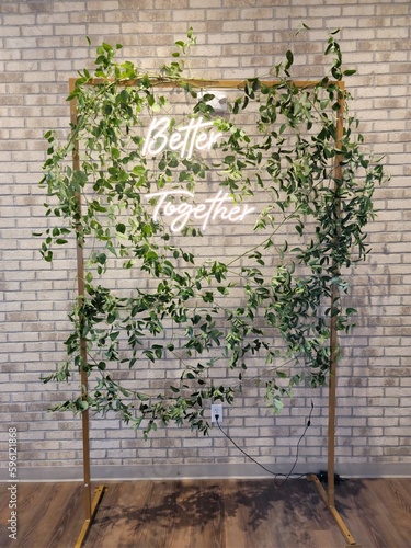 Wedding greenery backdrop with neon sign that’s says better together 