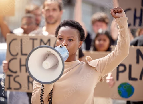 Obraz You will hear our voices. a young woman speaking through a megaphone at a protest.
