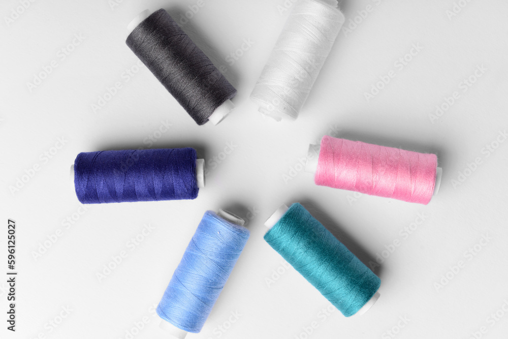 Composition with different thread spools on light background Composition with different thread spools on light background