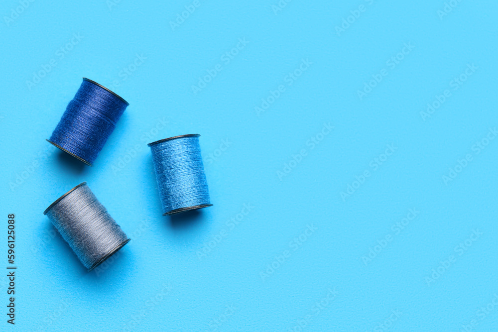 Fototapeta premium Sewing spools on color background