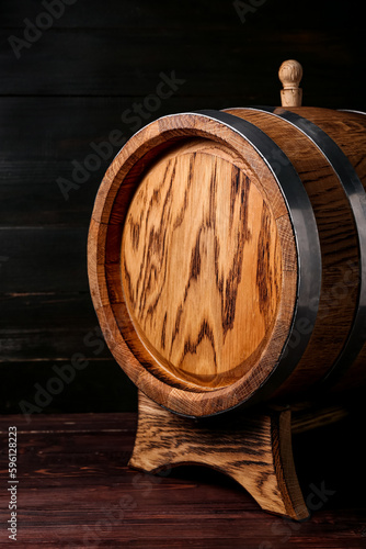 Oak barrel on dark wooden background, closeup