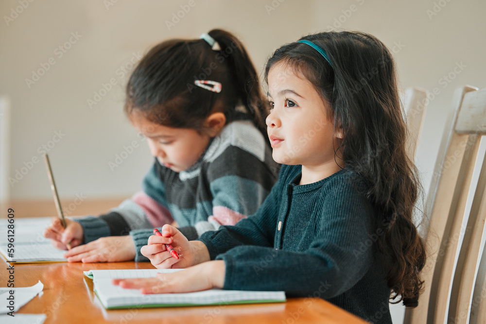 Time to focus on school. two sisters completing their homework together. Time to focus on school. two sisters completing their homework together.