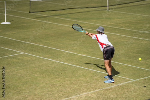 Amateur playing tennis at a tournament and match on grass in Europe  © Phoebe