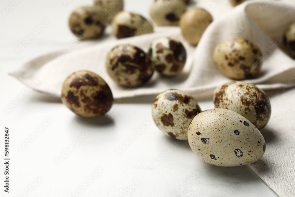 Fototapeta premium Many speckled quail eggs on white table. Space for text