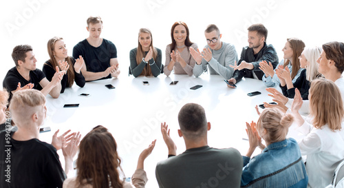 group of young people applauding, sitting at a round table