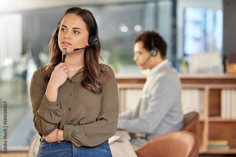 Shes always thinking of the brightest solutions. a young call centre agent looking thoughtful in an office with a colleague in the background. Shes always thinking of the brightest solutions. a young call centre agent looking thoughtful in an office with a colleague in the background.