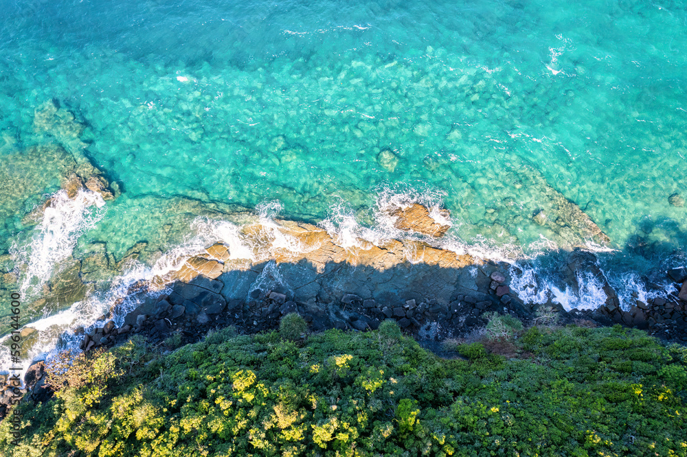Fototapeta premium Beautiful turquoise sea and wave crashing on coastline in summer