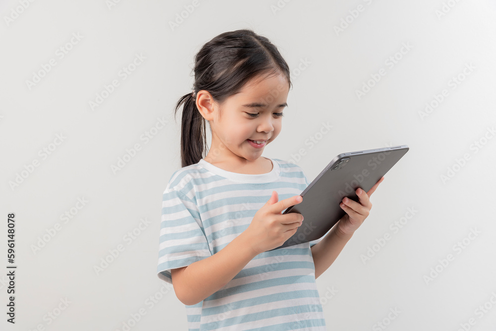smiling little girl stiiting and holding a tablet smiling little girl stiiting and holding a tablet