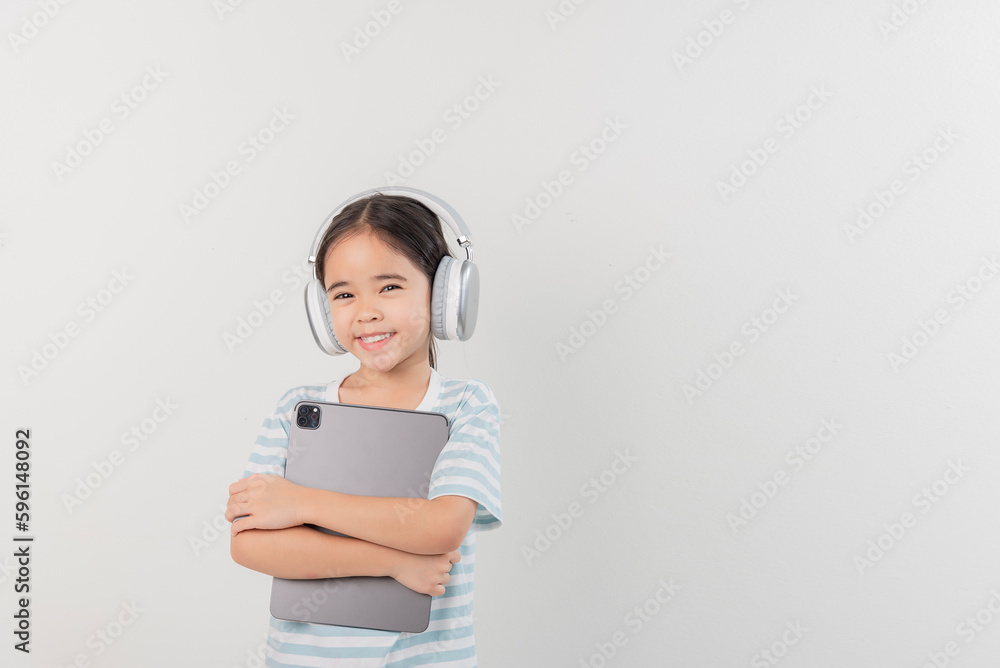 smiling little girl stiiting and holding a tablet with earphone smiling little girl stiiting and holding a tablet with earphone